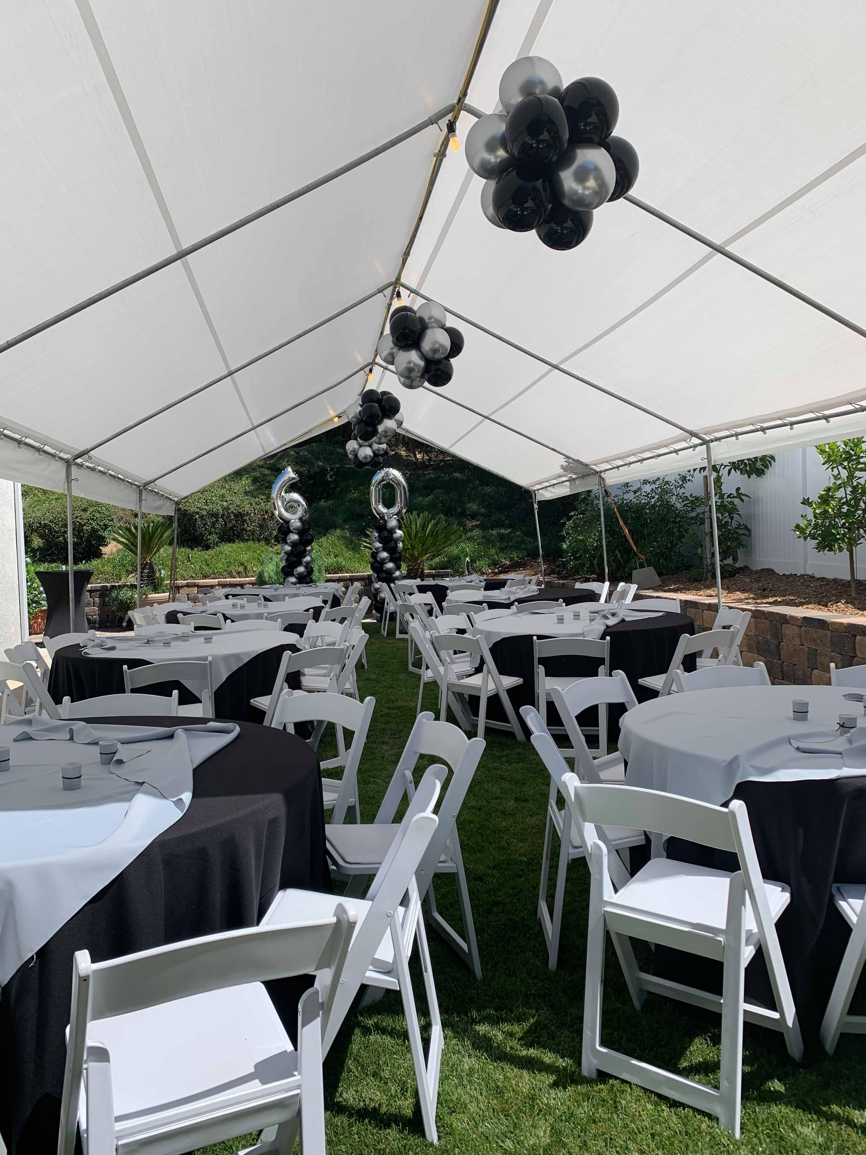 Pink themed tables and chairs setup under large canopy