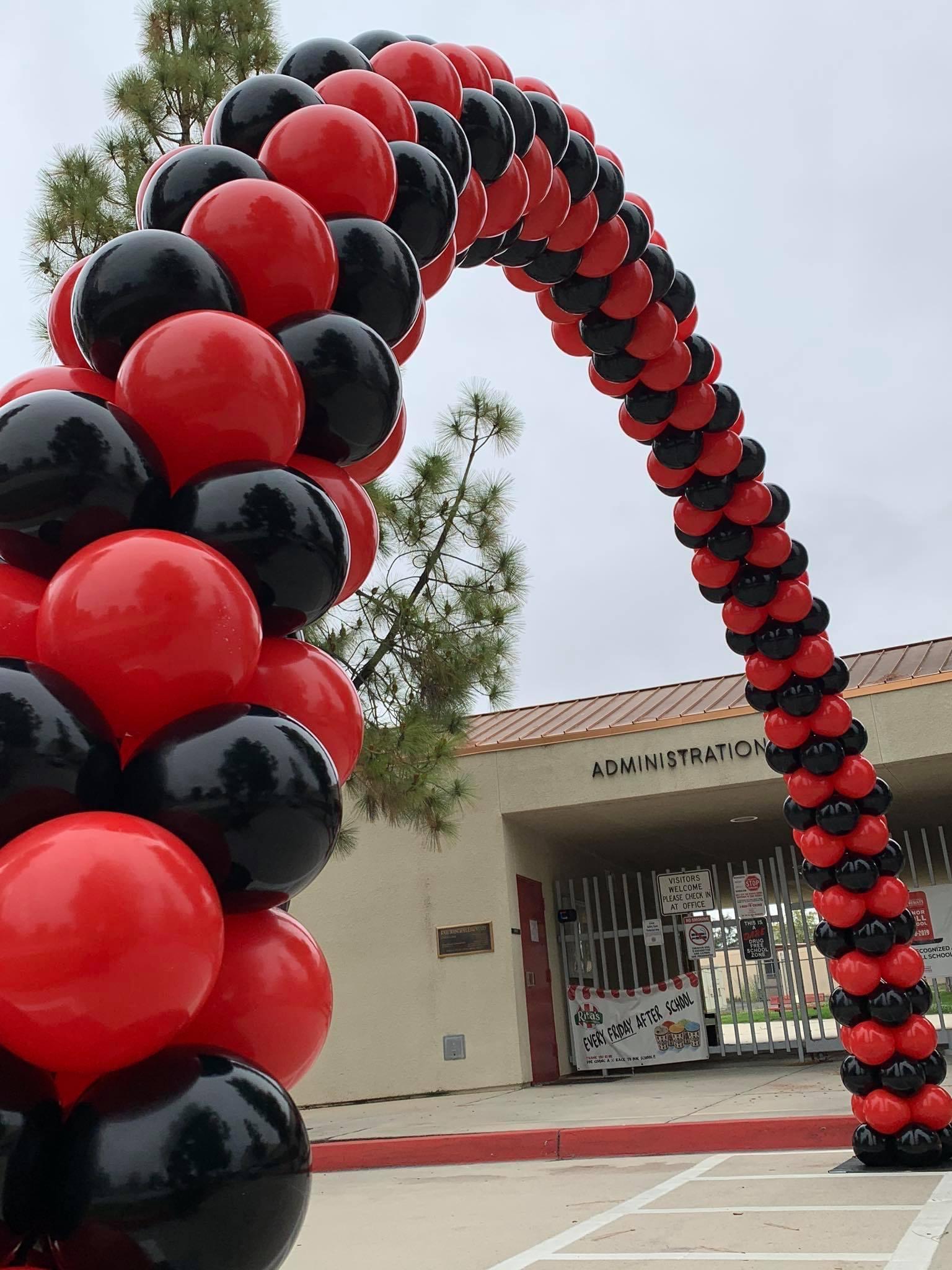 Massive red and black balloon arch way for school